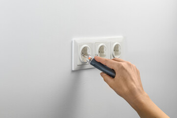 hand holding a non-contact network tester for measuring electrical, used to test electrical...