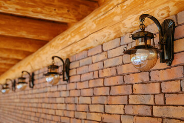 Wall-mounted metal street lamps, wooden gazebos near the house