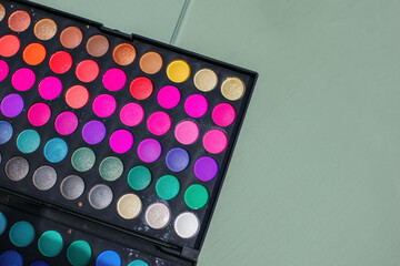 Rainbow eyeshadow palette, makeup palette on a turquoise background.