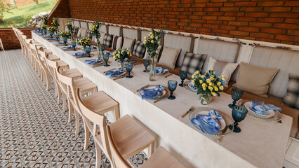 A table is set in a wooden gazebo near a house outside the city. Birthday decor.