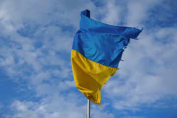 Ukrainian flag on the background of the blue sky. Unbreakable Ukraine