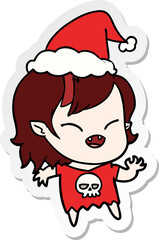 sticker cartoon of a laughing vampire girl wearing santa hat