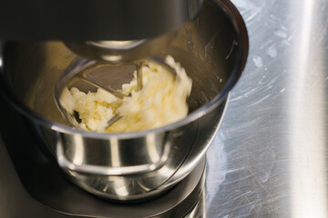 Making macarons. A silver kitchen table mixer kneads the dough for macarons.