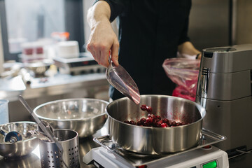 Close up. A chef weighs cherries for baking a fruit pie or other desserts.