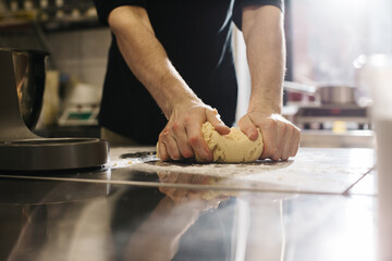 Close up. The cook kneads the dough with his hands, making macaroons or cakes.