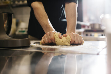 Close up. The cook kneads the dough with his hands, making macaroons or cakes.