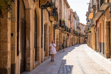 Street with tourist in the medieval city of Montblanc, Tarragona. Beautiful walled villa - obrazy, fototapety, plakaty