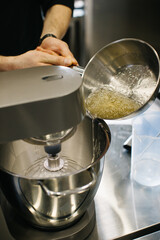 The chef works with a dough mixer. Adding caramel, close-up..