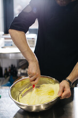 The chef works in the kitchen. The process of making dough for macaroons.