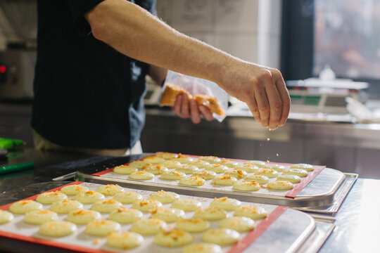 A confectioner makes macaroons in a pastry shop.