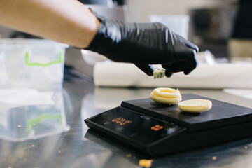 A confectioner makes macaroons in a pastry shop.
