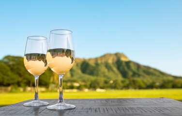 Hawaii summer holiday concept. Pair of wine glasses against a beautiful tropical Diamond head...