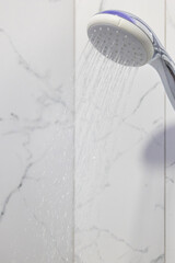 Stream of water splashing out of shower in modern bathroom. Jets of clean water flowing from shower head. High quality photo