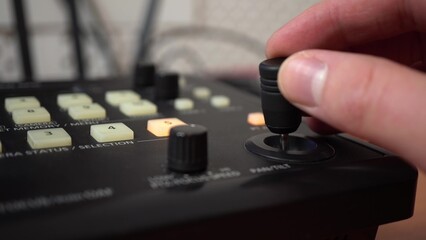Control panel for remote cameras. The man moves the joystick and presses the buttons. Hand close up. © Vital9c