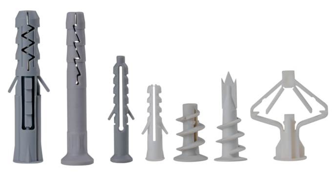 Plastic dowels of various types for fixing screws in the wall on an isolated background. Construction accessories used for repairs.