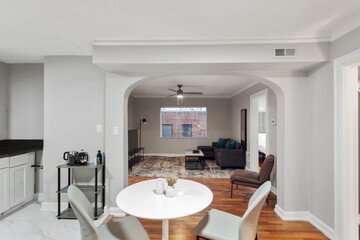White apartment with wide open spaces, hardwood flooring and modern furniture. Used as a short term rental. 
