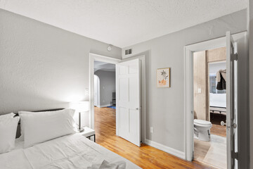 White apartment with wide open spaces, hardwood flooring and modern furniture. Used as a short term rental. 