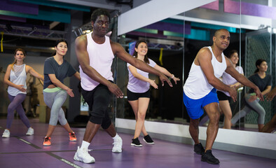 People dancing aerobics at lesson in the gym