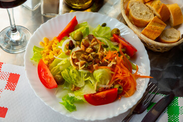 Light salad with goat cheese, fresh tomatoes, lettuce and carrot - dish of Spanish cuisine
