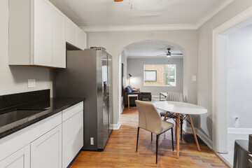 Fototapeta premium White apartment with wide open spaces, hardwood flooring and modern furniture. Used as a short term rental. 