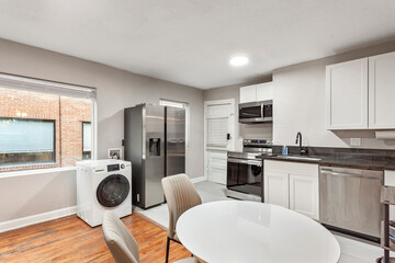 White apartment with wide open spaces, hardwood flooring and modern furniture. Used as a short term rental. 