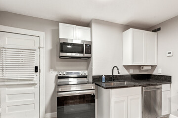 Fototapeta premium White apartment with wide open spaces, hardwood flooring and modern furniture. Used as a short term rental. 