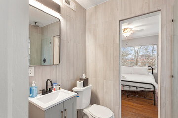 White apartment with wide open spaces, hardwood flooring and modern furniture. Used as a short term rental. 