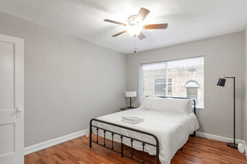 White apartment with wide open spaces, hardwood flooring and modern furniture. Used as a short term rental. 