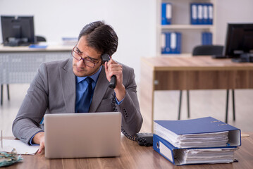Fototapeta premium Young male employee talking by phone