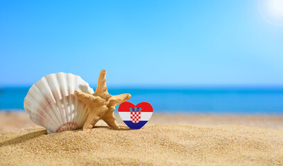 Beautiful beach in Croatia. Flag of Croatia in the shape of a heart and shells on a sandy beach.