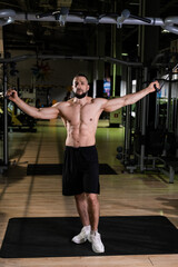 Fototapeta na wymiar A muscular man with a beard trains in the gym