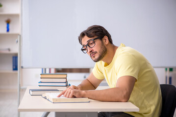 Young male student preparing for exams in the classroom