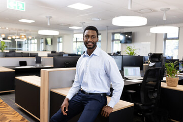 Happy african american businessman looking at camera in office