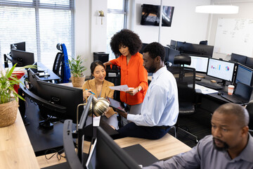 Diverse female and male businesspeople working in office with open space