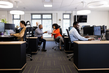 Diverse female and male businesspeople working in office with open space