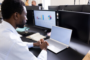 African american man working on laptop with copy space in office