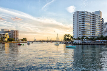 Downtown Miami, Florida south beach with biscayne bay intracoastal water boats at sunset with apartment condo buildings on peaceful evening cityscape
