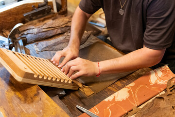 close up of man rolling cigar