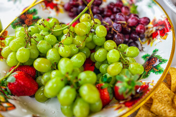 Green grapes grape fruit with red whole food closeup on plate bowl party platter and strawberries