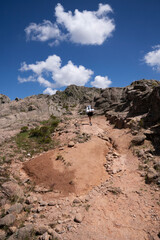 View of a young woman hiking along the path in the rock massif The Giants in Cordoba, Argentina.