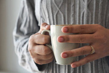 Close up of women's hand holding coffee mug 