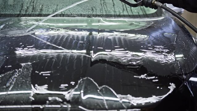 Checking before applying a layer of ceramic protective coating anti-rain on the car surface to prevent corrosion and oxidation, sun and water damage. Carwash or Car Detailing process
