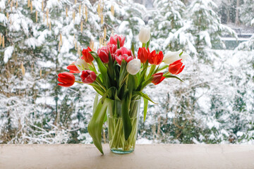 A bouquet of tulips on the windowsill in winter