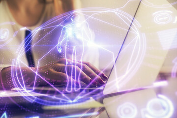Double exposure of woman hands typing on computer and general theme hologram drawing. Education concept.