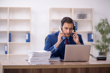 Young male employee and too much work in the office