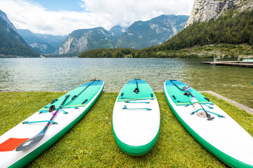 Inflatable SUP boards on the shore of an Alpine lake