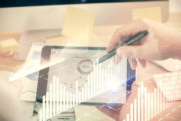 Double exposure of man's hands holding and using a phone and financial chart drawing. Market analysis concept.