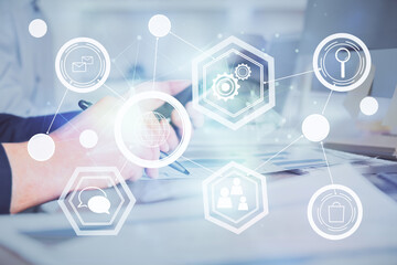 Double exposure of man's hands holding and using a phone and social network theme drawing.