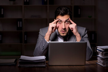 Young male employee working late in the office