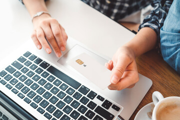 Top down view person holding a credit card over laptop keyboard